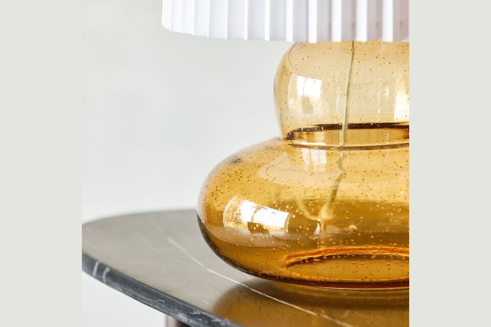 This sophisticated fixture harmoniously combines amber-tinted glass and a pleated fabric shade