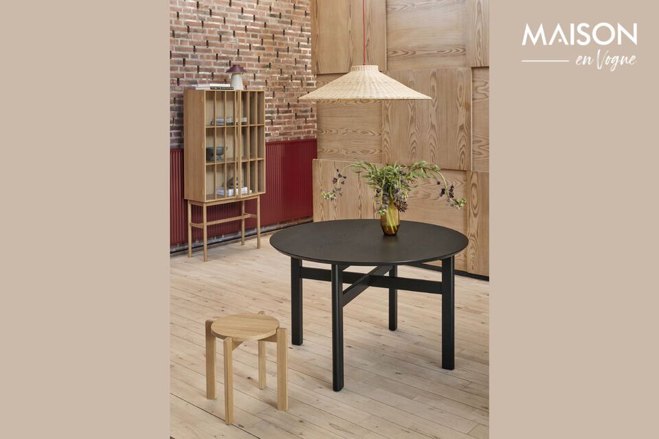 This round dining table in black ash wood offers an elegant and intimate meeting space